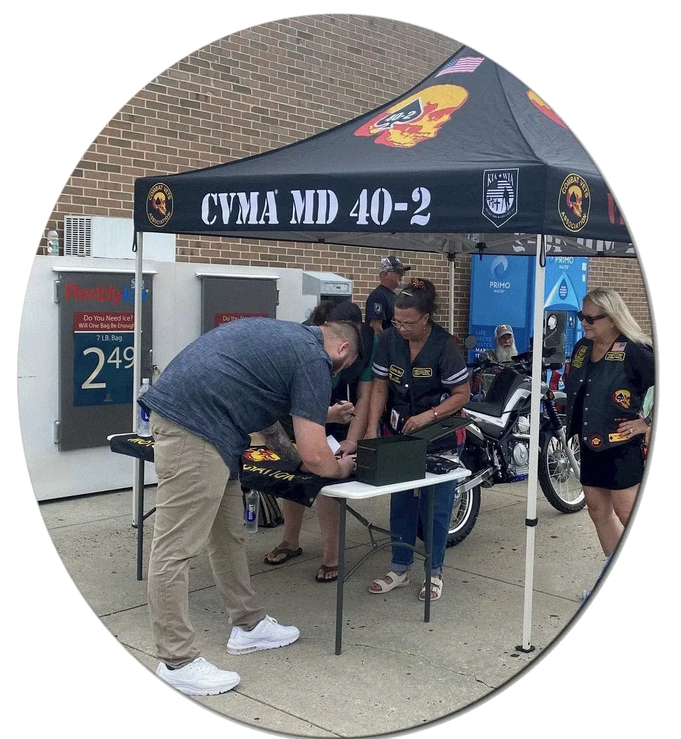 People gathered under a Cyma MD 40-2 promotional tent outdoors.