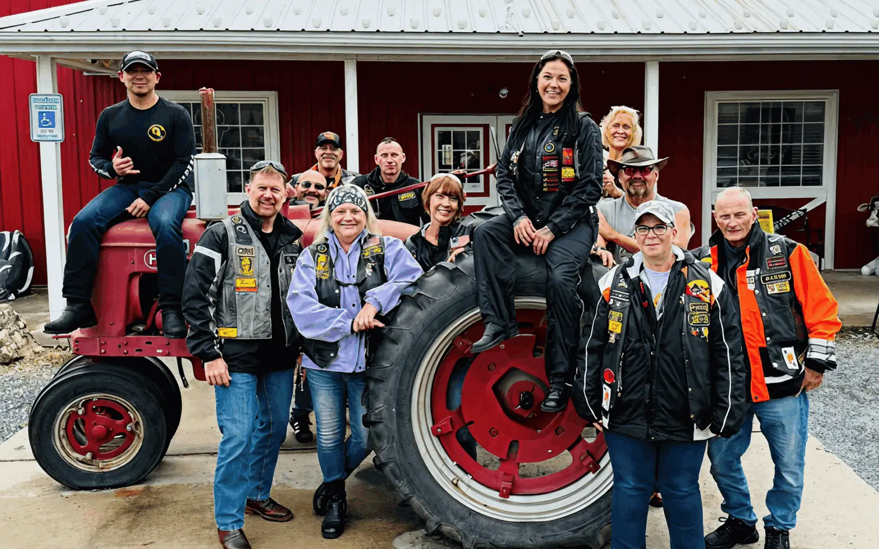 Group posing with a red tractor.